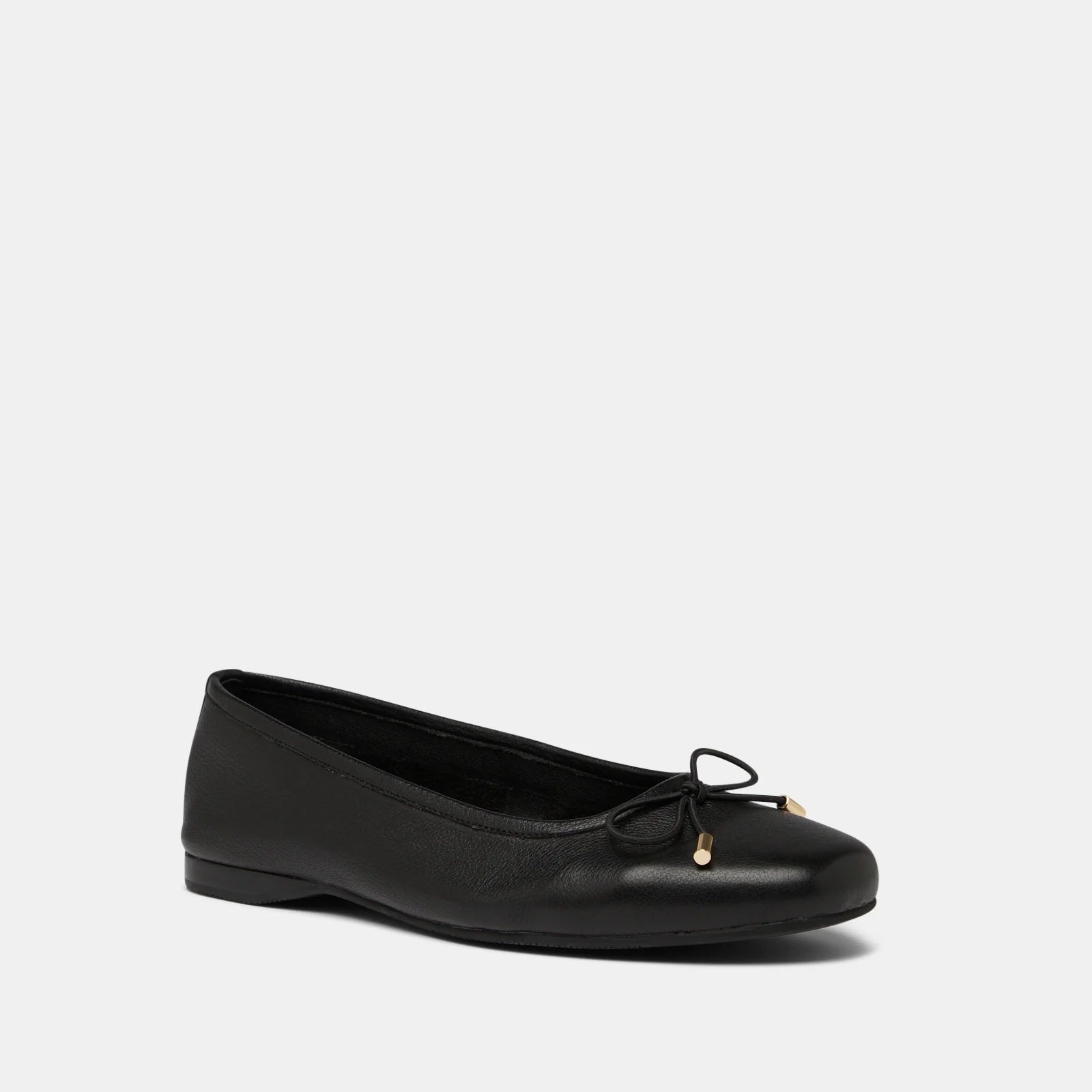 Black leather flat shoe with a bow on a light gray background