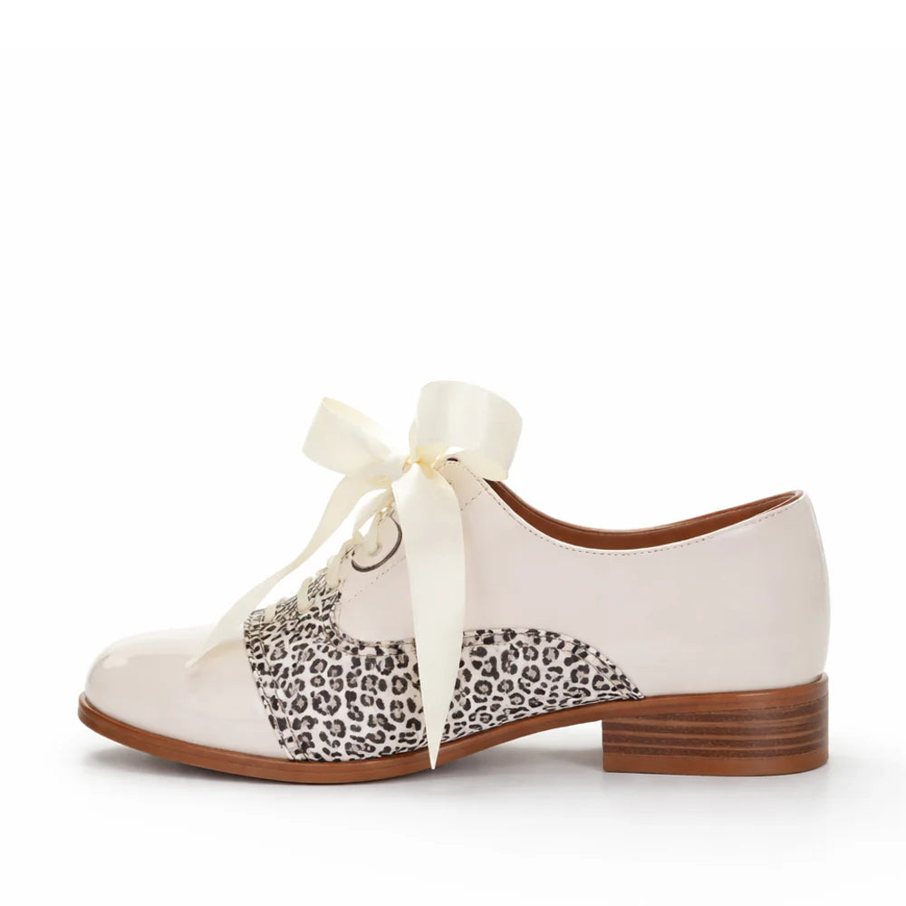 White shoe with leopard print ribbon on a white background