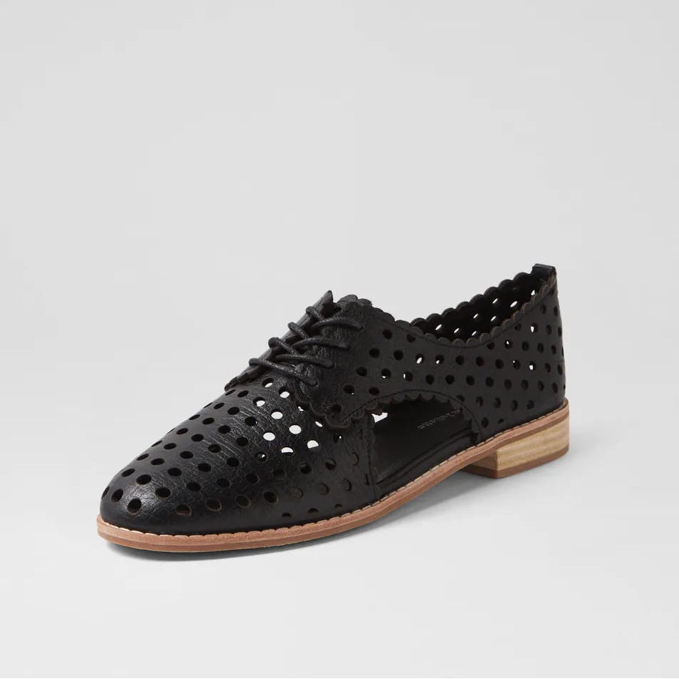 Black perforated leather shoe on a light gray background
