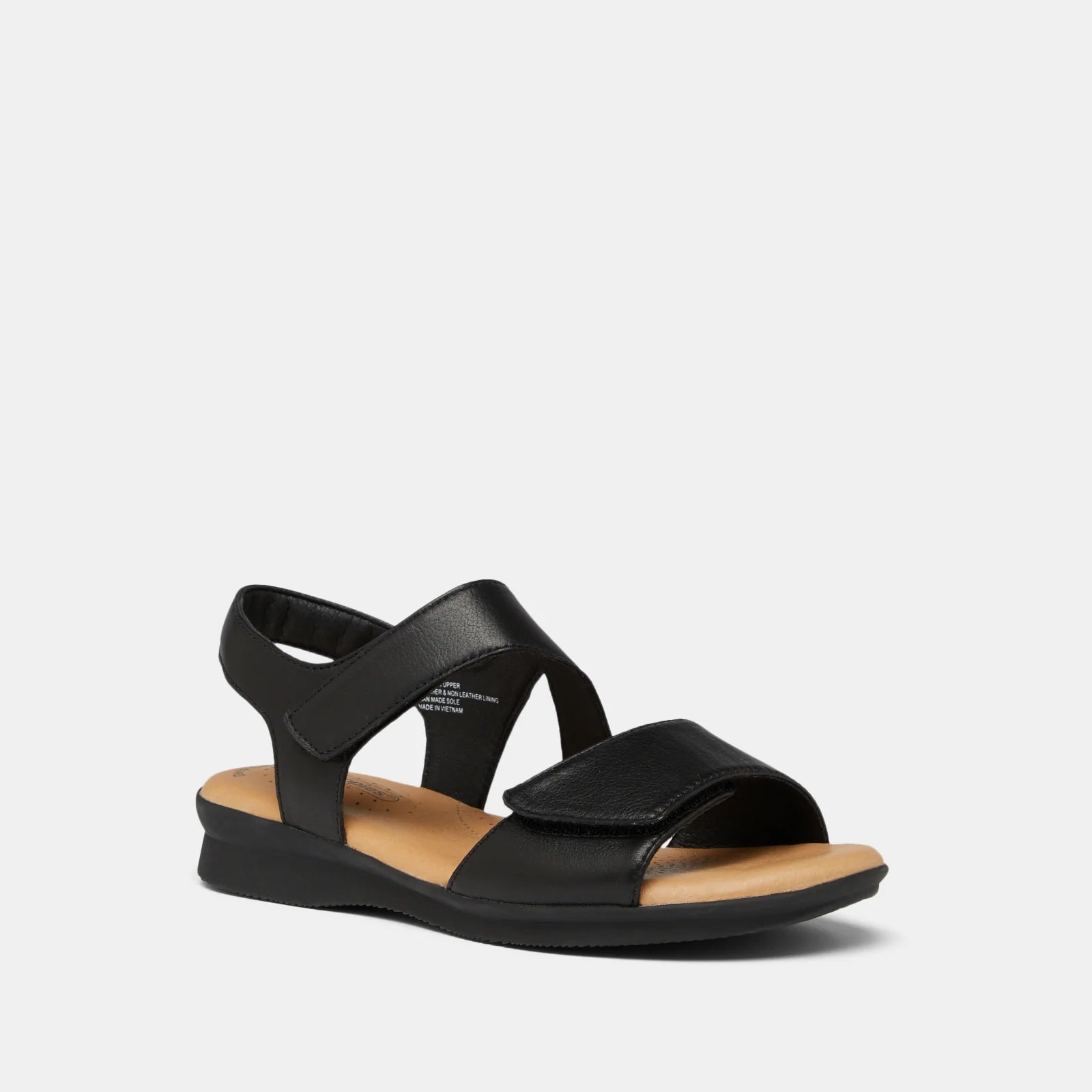 A single black leather sandal with crisscross straps and a low wedge heel, shown from a side profile on a light gray background.
