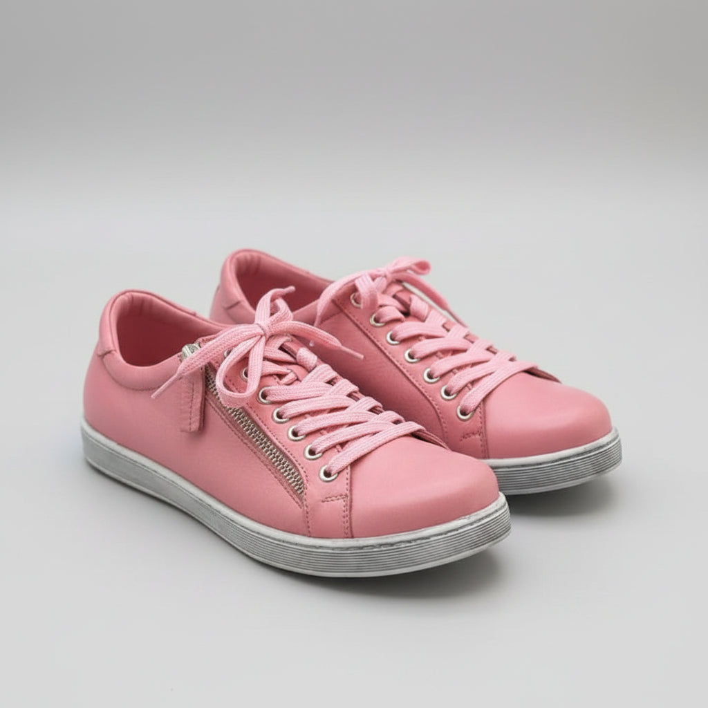 Pink sneakers with pink laces on a wooden surface