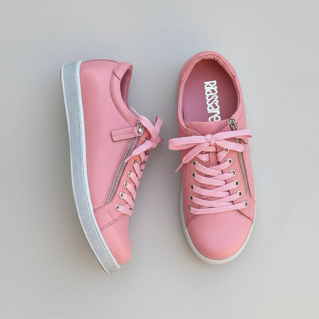 Pink sneakers with zippers on a wooden surface