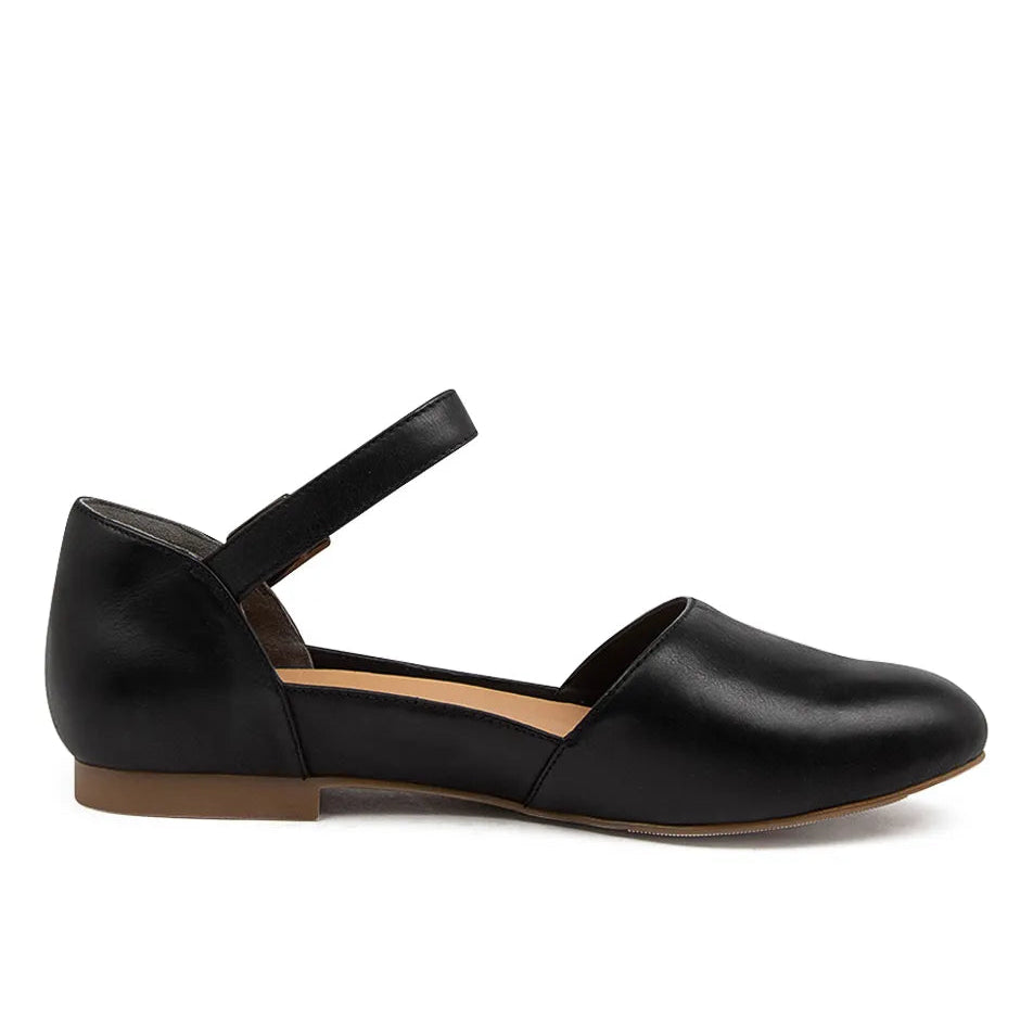 Black flat shoe with a strap on a white background