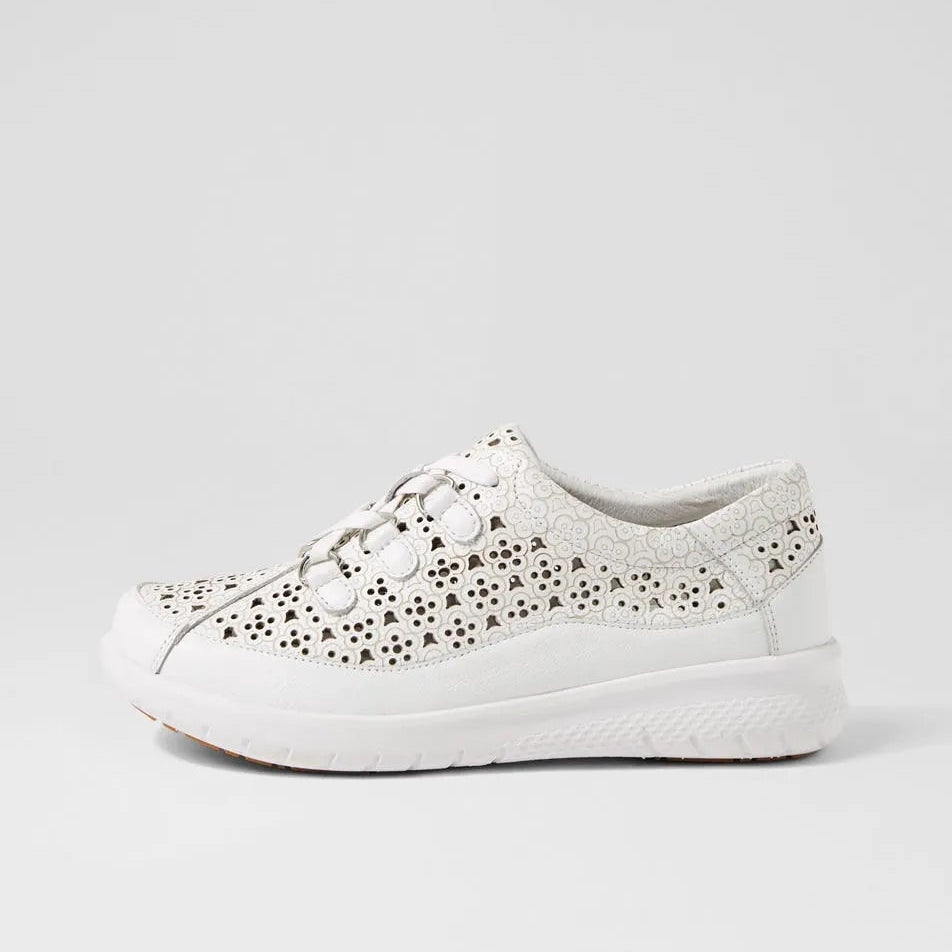 White sneaker with decorative cut-out pattern on a light gray background