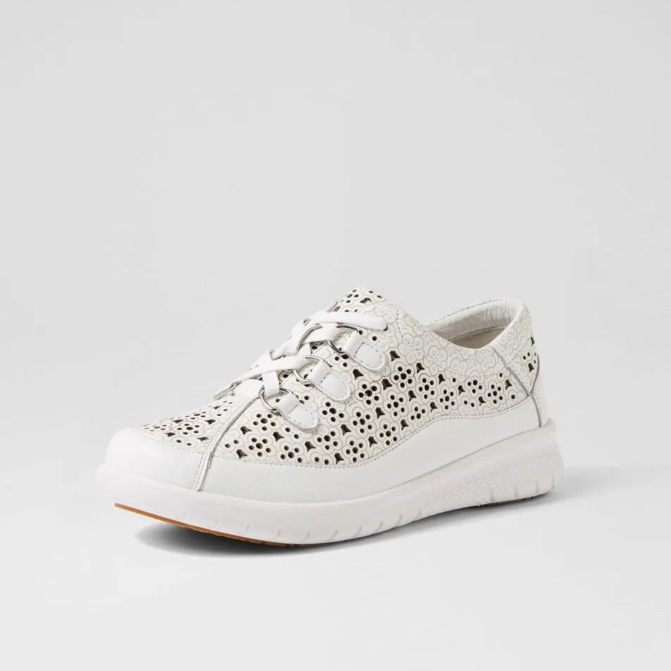 White sneaker with black perforations on a light gray background